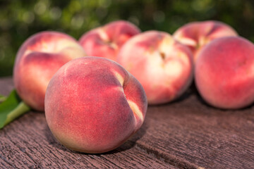 Fototapeta na wymiar Fresh Peach fruits in blur background, Peach on wooden table in garden.