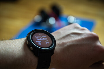 Fototapeta premium Workout at home. Close up shot of smartwatch which shows productive training. Sport watch shows info about workouts.