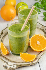 Healthy green smoothie with spinach in glass jars.