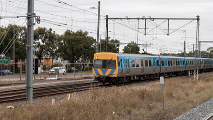 Fototapeta premium Commuter train approaching a train station in Melbourne Victoria Australia