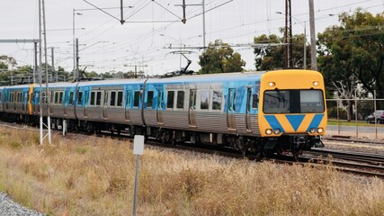 Obraz premium Commuter train approaching a train station in Melbourne Victoria Australia