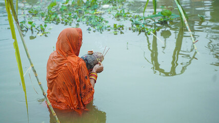 Woman in the middle of the lake celebrating chhath festival  