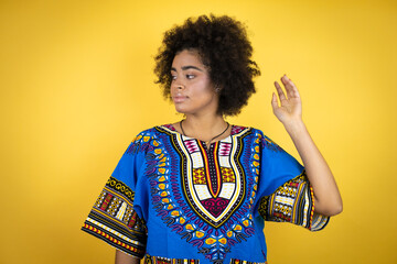 African american woman wearing african clothing over yellow background with a happy face standing and smiling with a confident smile showing teeth