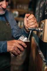 middle aged man bartender serving beer in beer pub