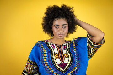 African american woman wearing african clothing over yellow background with a happy face standing and smiling with a confident smile showing teeth
