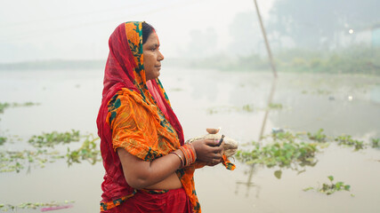 Woman worshipping to sun during chhath puja