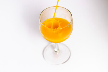 Orange juice is being poured into the glass. Drink