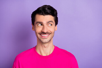 Photo of sweet attractive young man wear pink t-shirt smiling looking empty space isolated purple color background