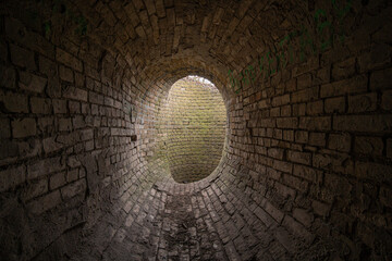 Old abandoned oval brick tunnel  of the 19th century in the day. Old drainage system.