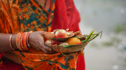 Woman holding fruits in hand during chhath puja
