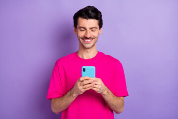 Photo of young happy cheerful good mood positive man blogger influencer use cellphone isolated on violet color background