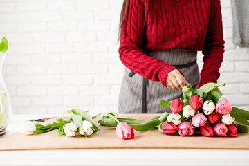 Woman florist making a bouquet of fresh colorful tulips