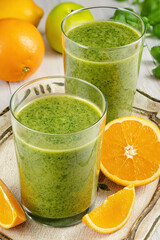 Healthy green smoothie with spinach in glass jars.
