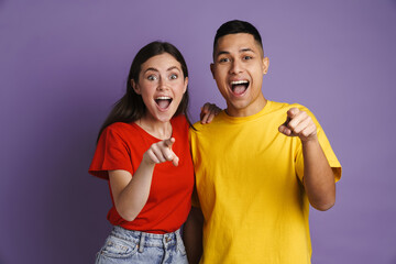 Obraz premium Excited beautiful couple screaming and pointing fingers at camera