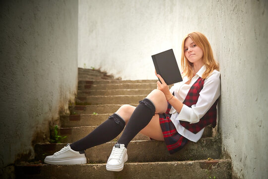 Young Girl With Short Hair In A School Checkered Uniform Outdoors.