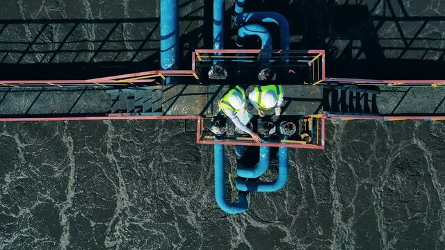 Top view of two workers standing on the sewage cleaning construction