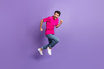 Full length profile portrait of excited person running toothy smile look camera isolated on purple color background
