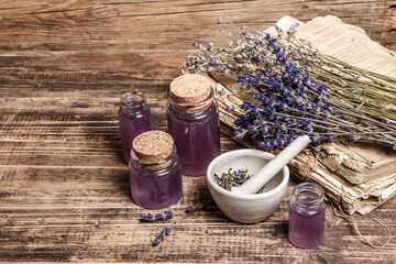 Dried lavender flowers in a in a mortar and pestle with bottle of essential lavender oil or infused...