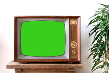 old retro TV with blank green screen for a designer, video film stands in a light room on a wooden...
