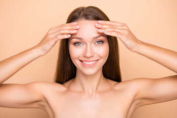 Photo of young girl happy positive smile hands touch forehead cleansing skin isolated over beige color background