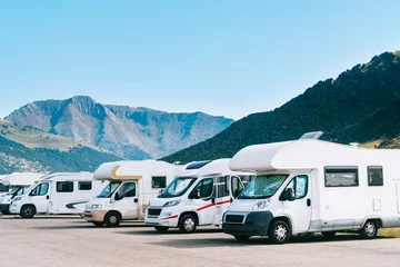 Summer tourism with rv in the mountain. Campers parked in a row in a caravan parking area. Best option for travel feeling free. Motorhomes and campingcar. © Pol Solé