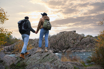 Couple of hikers enjoying beautiful view near mountain river, back view