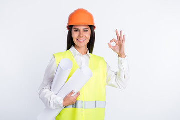 Photo of adviser lady hold rolls paper fingers show okey wear helmet shirt vest isolated white color background