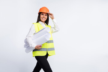 Photo of worker lady hold rolls paper go beaming smile wear helmet shirt vest isolated white color background