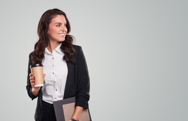 Smiling businesswoman with takeaway coffee and documents