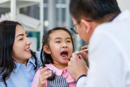 Dentist examining teeth of little girl  at dental clinic