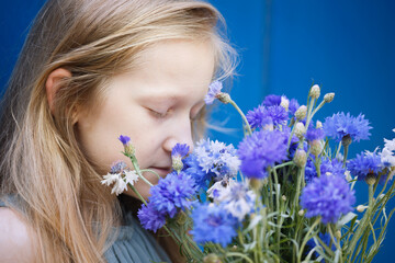 girl holding a bouquet of centaurea © Sergii Mostovyi