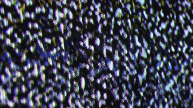 Close up view at a plasma tv while showing white noise activity.