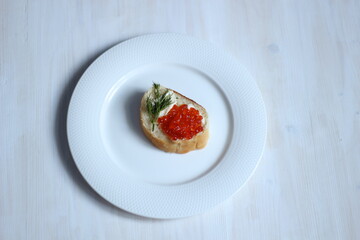 Not fresh, yesterday open sandwich with red caviar, dill, butter on white plate