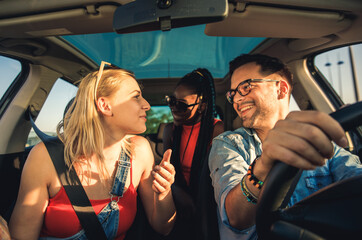 Three best friends enjoying traveling at vacation in the car.