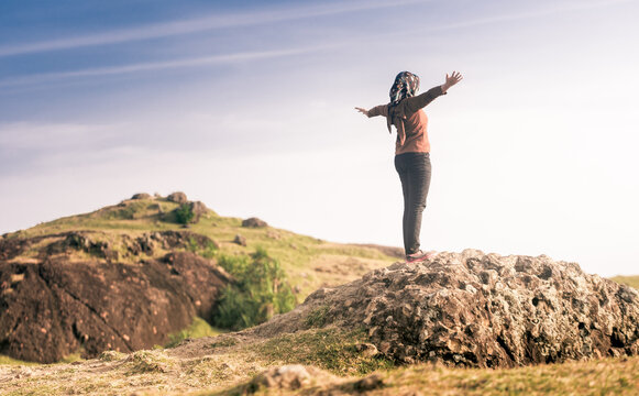 A woman enjoying the view on a tropical savanna of merese hills, lombok island. before sunset. https://www.lombokjourney.com