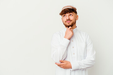 Young Arab man wearing the typical arabic costume isolated on white background looking sideways with doubtful and skeptical expression.