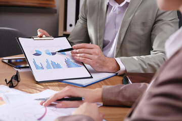 Business people working with charts and graphs at table in office, closeup. Investment analysis