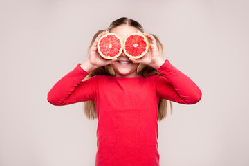 Funny girl playing with grapefruit