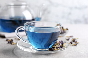 Glass cup of organic blue Anchan on light table. Herbal tea