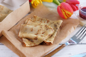 Portion of pancakes on craft paper on white table