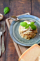 Italian  home made creamy   mushroom risotto with parmesan cheese and fresh basil on rustic background