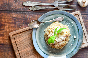 Italian mushroom risotto with parmesan cheese and fresh  parsley on rustic background