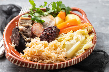 typical portuguese dish boiled meat, smoked sausages and vegetables on ceramic dish