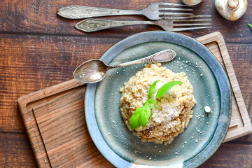 Italian mushroom risotto with parmesan cheese and fresh  parsley on rustic background