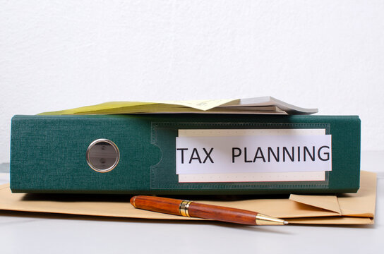 Paper work and process of tax planning.Folder, pen, documents on the desk against white background.Empty space