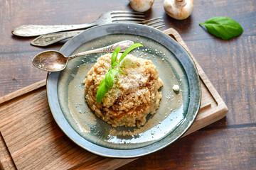 Italian mushroom risotto with parmesan cheese and fresh  parsley on rustic background