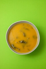 vegetable soup with spinach in the bowl on green background