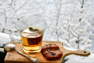 Cup of tea with cinnamon and home made peanut butter on a balcony in a snowy winter day 