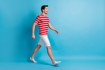 Full length body size side profile photo of guy cheerful going forward on meeting isolated on vibrant blue color background