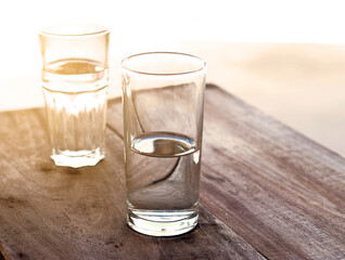 two Glasses clean of water on a wooden table.